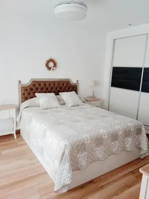 a white bedroom with a large bed with white comforter at Casa con PISCINA y CINE in Paterna