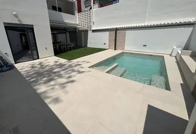 a swimming pool in the courtyard of a building at Casa con PISCINA y CINE in Paterna