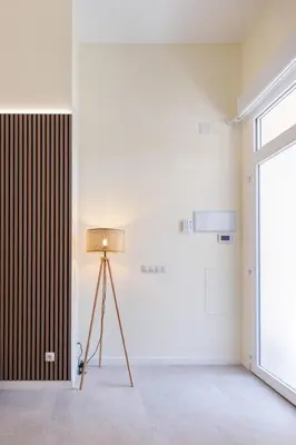 a floor lamp in a room with a white wall at Benimamet Suite by Concept Flats in Valencia