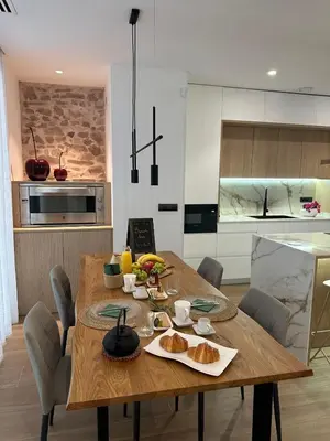 a wooden table with bread on it in a kitchen at Casa Rural con piscina privada en casco urbano de Náquera Botigueta 25 in Náquera