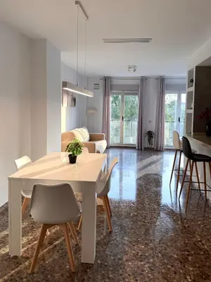 a living room with a white table and chairs at Apartamento turístico Playa Valencia in Valencia