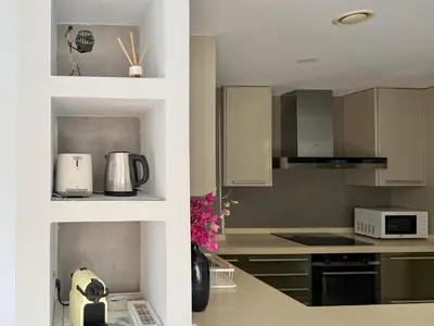 a kitchen with white cabinets and a counter top at Apartamento turístico Playa Valencia in Valencia