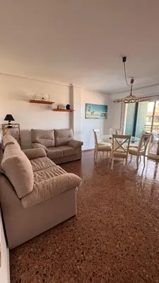 a living room with a couch and a dining room at Apartamento entero Playa Perello Valencia in El Perelló