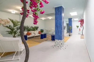 a lobby with a tree and pink flowers at Carmen Beach Hostel Cullera in Cullera