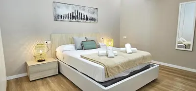 a bedroom with a large bed with two lamps at Vacansis Valencia Bajo Torrefiel in Valencia