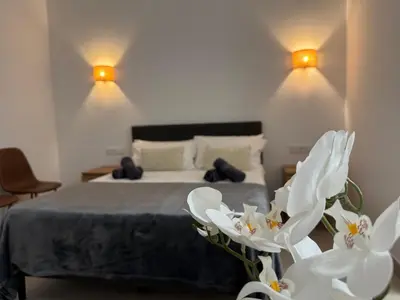 a bedroom with a bed with white flowers in the foreground at Basset 1 in Valencia