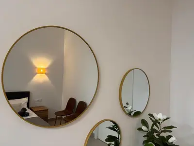 two mirrors on a white wall with a table and chairs at Basset 2 in Valencia