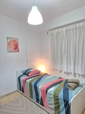 a bedroom with a bed with a striped blanket at All you need in Valencia
