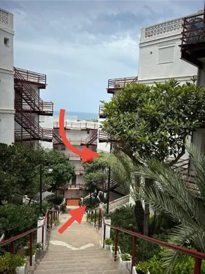 two red arrows pointing to a building with trees at Faro Cullera Sea view in Faro de Cullera