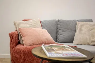 a couch with a table with a magazine on it at Bright & Modern Apartment - Rose y Maya in Valencia