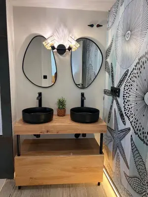 a bathroom with two sinks and two mirrors at Barco - casa con jardín privado frente al mar in Mareny Barraquetas