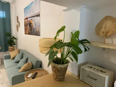 a living room with a blue couch and a potted plant at Casa Playa El Perelló in El Perelló