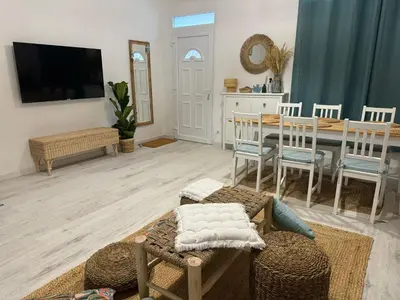 a living room with a table and a tv at Casa Playa El Perelló in El Perelló