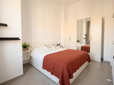 a bedroom with a bed with a red blanket at Across from the Turia Modern City Stay in Valencia