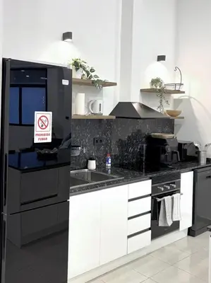 a kitchen with black and white counters and a sink at Across from the Turia Modern City Stay in Valencia