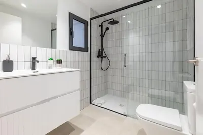 a white bathroom with a shower and a toilet at My Loft 4 You Democracia I in Valencia