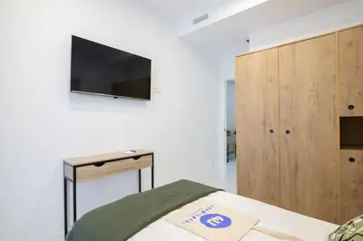 a bedroom with a bed and a tv on a wall at Dorm4You Calle Gibraltar 15 Ruzafa Apartments in Valencia