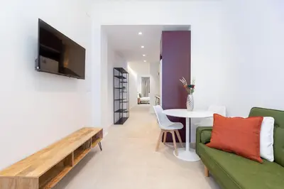 a living room with a couch and a table at My Loft 4 You Democracia II in Valencia