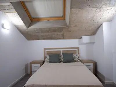 a bedroom with a bed with a wooden head board at Apartment San Pedro 4 in Valencia