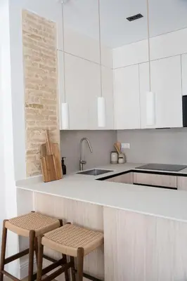 a kitchen with a white counter and two stools at Valencia Boutique Stays - High End Apartment in Ruzafa for long stays in Valencia
