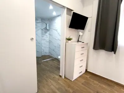 a room with a tv and a dresser with a television at Estudio tranquilo cerca del Centro in Valencia