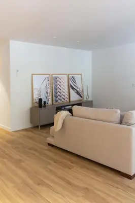 a living room with a couch and paintings on the wall at VLC Host - Belgica Apartments in Valencia