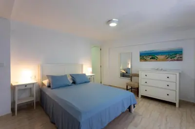 a bedroom with a blue bed and a dresser at Casa La Mar in Mareny Blau