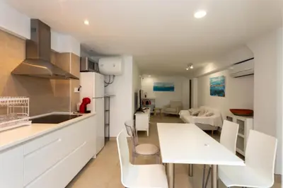 a kitchen and living room with a table and chairs at Casa La Mar in Mareny Blau