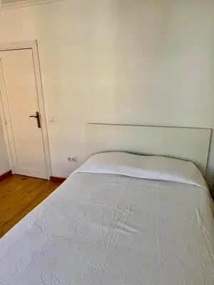 a white bed in a room with a door at Private Room in Central Valencia in Valencia