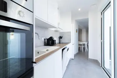 a kitchen with white cabinets and a sink at Global Vacacional, Deslumbrante casa en la playa de Sagunto in Sagunto