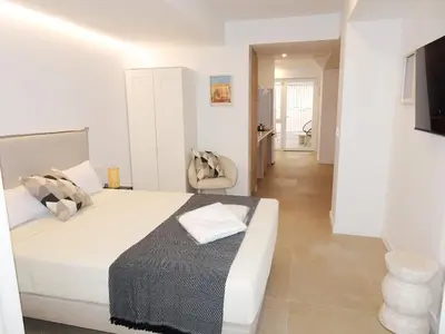 a white bedroom with a bed and a chair at JB22 - Loft Valencia in Valencia