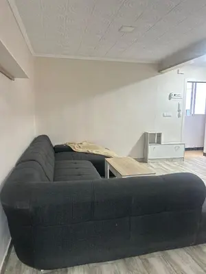 a black couch in a room with a table at Apartamento acogedor playa Cullera in Cullera