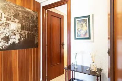 a hallway with a door and a table and a picture at Global Vacacional, Vivienda cozy en Puerto de Sagunto in Puerto de Sagunto