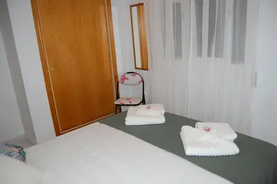a room with a bed with two towels and a chair at BRISA DEL MAR en primera línea in Torres-Torres