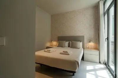 a bedroom with a large bed with two lamps on it at VLC Host - Martí Apartments in Valencia