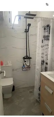 a bathroom with a toilet and a shower curtain at Seaview escape - spacious 3 bed beach apartment & terrace in Puerto de Sagunto