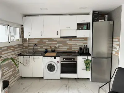 a kitchen with white cabinets and a washing machine at Seaview escape - spacious 3 bed beach apartment & terrace in Puerto de Sagunto