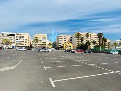 an empty parking lot with cars parked in it at Seaview escape - spacious 3 bed beach apartment & terrace in Puerto de Sagunto