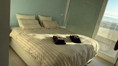 a bed with two bags on it with a window at Gran Canet, sea view 2beds in Canet de Berenguer