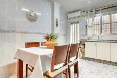 a dining room with a table and chairs and a kitchen at Casa Playa Arenas con Terraza in Valencia