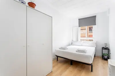 a white bedroom with a bed and a mirror at GuestReady - Comfort in Valencia in Valencia