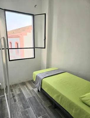 a small room with a bed and a window at Habitaciones La Estación in Algemesí