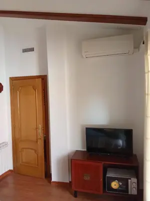 a room with a tv on a table with a door at Valencia Casa Rosa in Sedaví