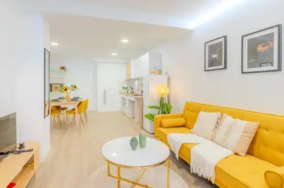 a living room with a yellow couch and a table at VL - Casa Girasol in Valencia