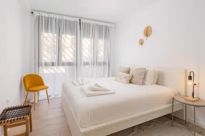 a white bedroom with a white bed and a window at VL - Casa Girasol in Valencia