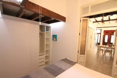 a bedroom with a bed and a dining room at Modernist house in Cabanyal in Valencia