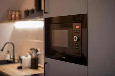 a microwave oven in a kitchen next to a sink at Grandma's fishermen's house in Cabanyal in Valencia