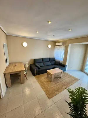 a living room with a blue couch and a table at 1st Line Beach Direct Access Private Parking in Valencia