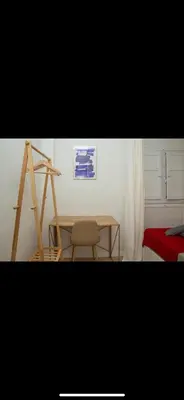 a room with a table and a chair and a painting at Habitación luminosa en piso compartido in Valencia