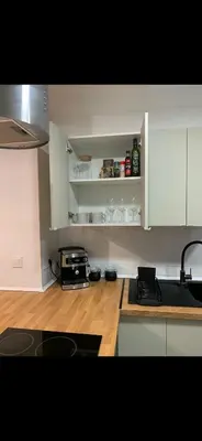 a kitchen with white cabinets and a wooden floor at Habitación luminosa en piso compartido in Valencia